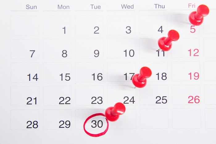 Calendário com alfinetes vermelhos e o dia 30 circulado